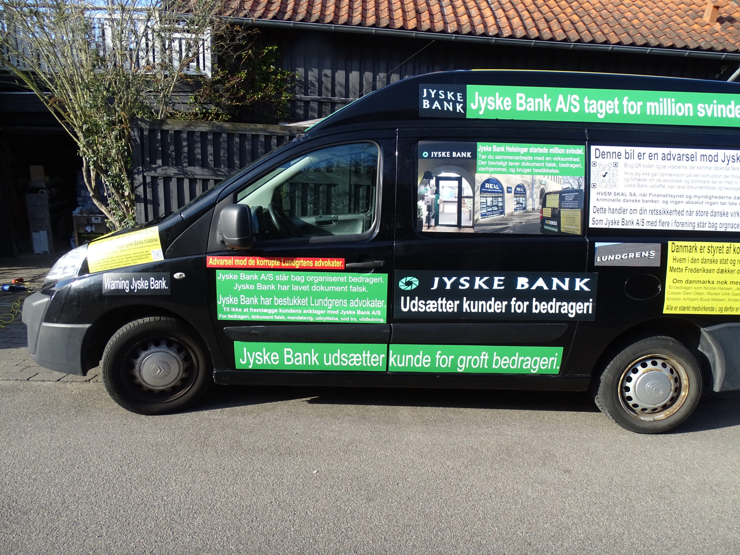 Jyske Bank bilen foran den kriminelle Jyske Bank i Helsingør, reklame for Jyske Banks forretnings metoder Myndighederne i Danmark får alle her i denne mail kraftig kritik 03-07-2022. Dels for at ignorer Jyske Banks mange strafbare forhold. Men også for at dækker over denne organiseret kriminalitet, som Jyske Bank bevisligt står bag, og så for at have forholdt jer passive og ikke vil blande jer i Jyske Banks mange lovovertrædelser. LYT og læs teksten, der står intet om nogle retssag, men blot at Jyske bank er kriminelle, og der nævnes flere lovovertrædelser, og navne på nogle af dem der for Jyske Bank A/S har medvirket til bedrageri. Hvilket Jyske Banks ansatte 22 juni. ikke vil afvise, og derfor undviger at svare på spørgsmålet, da en kunde spørger direkte om er det sandt det som står på bilen. Lydafspiller 00:00 00:00 Brug op/ned piletasterne for at skrue op eller ned for lyden. Hvad er det nu jeg skriver på Jyske Bank bilen. I hvert fald ikke noget politiet vil tage sig af, de kunder som Jyske Bank udsætter for groft bedrageri, de må klare sig selv, det er nemlig politiske at det ikke er politiets opgave, at hjælpe de kunder som banker udsætter for bedrageri. Derimod er det politiets opgave at efterforske og retsforfølge de kunder, som laver bedrageri mod banker, eller forsøger at udsætte banker som Jyske Bank for bedrageri. Jeg må ikke få hjælp, da Jyske Bank A/S ved kammerateri er beskyttet mod efterforskning og strafforfølgning.